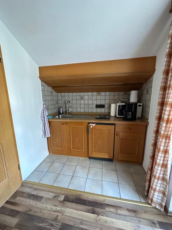 una pequeña cocina con fregadero y microondas en Apartment Kranzberg, en Mittenwald
