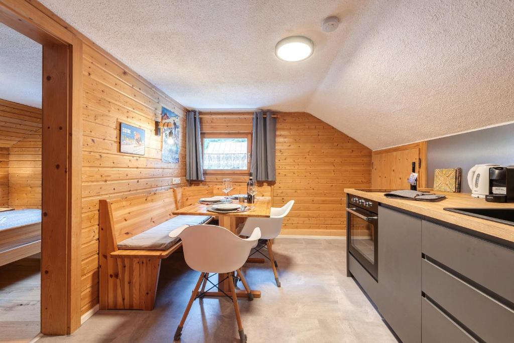 a kitchen with wooden walls and a table and chairs at Chalet Stanzertal in Strengen
