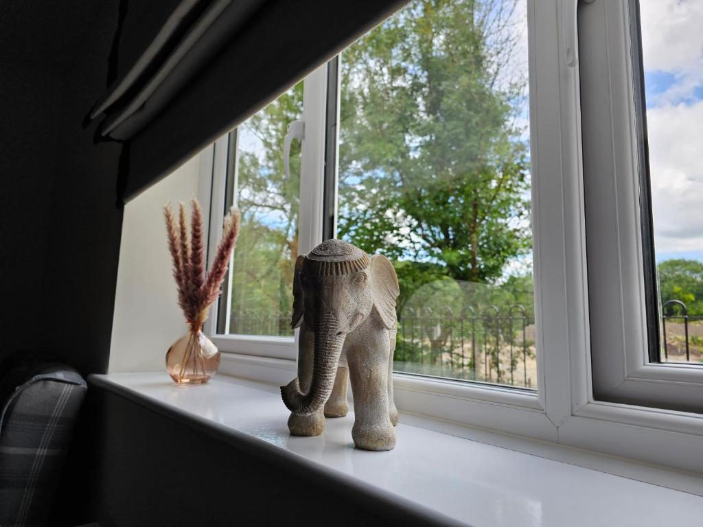 Une statue d'un éléphant assis sur un rebord de fenêtre dans l'établissement Oakmere Apartments, à Chinley