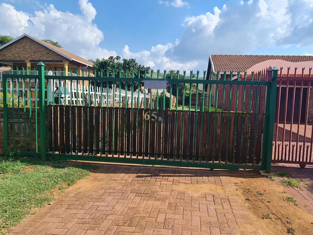 um portão de metal negro em frente a uma casa em B&O's Place em Pretoria