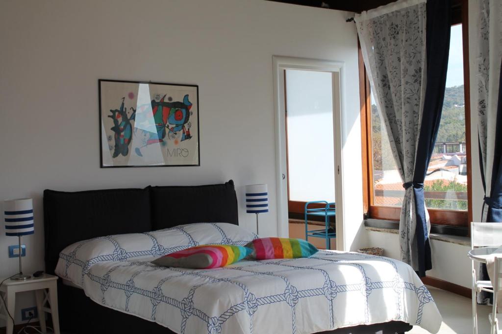 a bedroom with a bed with a rainbow pillow at Il Caimano B & B, con piscina gratuita dal 18 Luglio al 30 Agosto in Vulcano