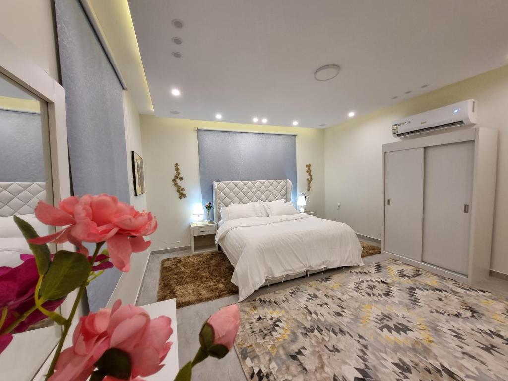a bedroom with a white bed and a large window at ملحق فخم جداً متكامل بسطح مستقل ومدخل مستقل in Abha