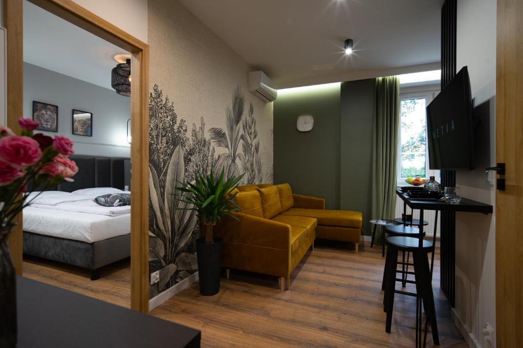 a hotel room with a bed and a yellow couch at FREEDOM APART Akacjowa 17m1B in Zielona Góra