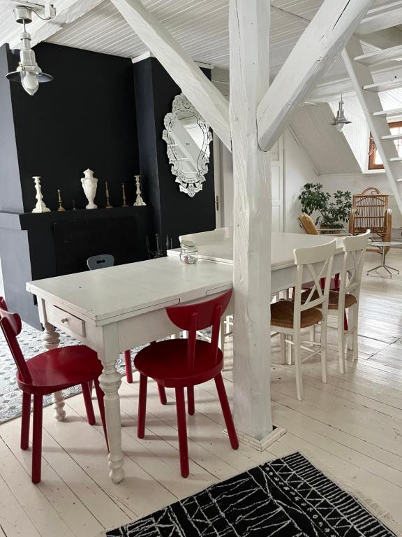 a dining room with a white table and red chairs at Górna79 in Jugowice