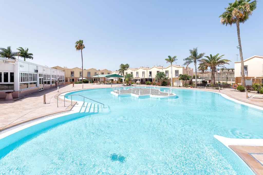 a large swimming pool at a resort with palm trees at Villetta Green oasis club in Maspalomas