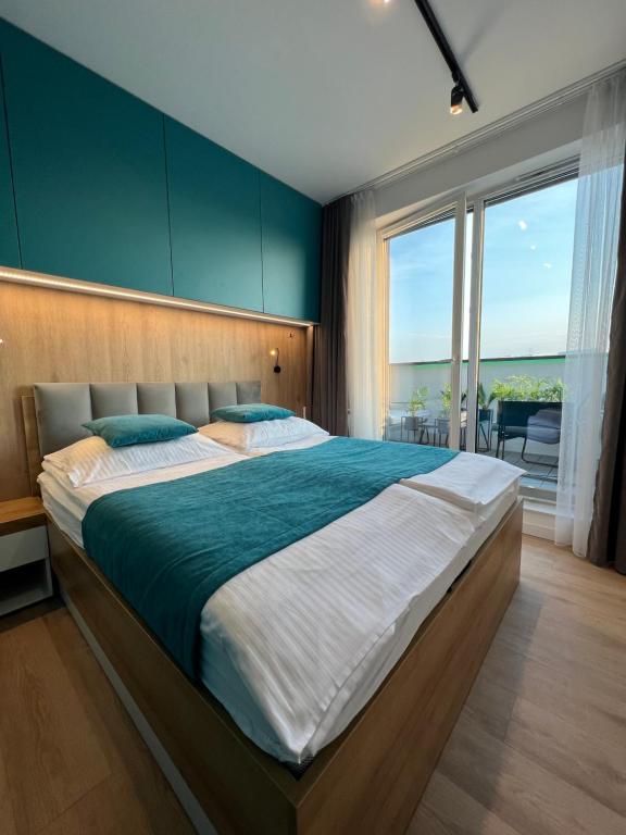 a bedroom with a large bed and a large window at Apartament Fredry 2 PREMIUM KLIMA in Kołobrzeg