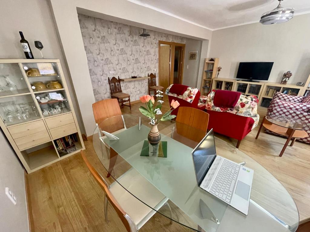 sala de estar con mesa de cristal y ordenador portátil. en ENTRELASVIÑAS, en Cariñena