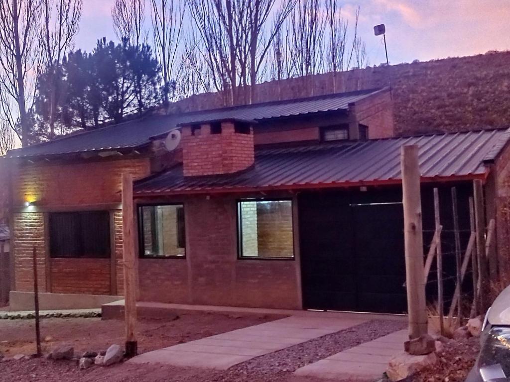 een stenen huis met een garage ervoor bij LC House in Potrerillos