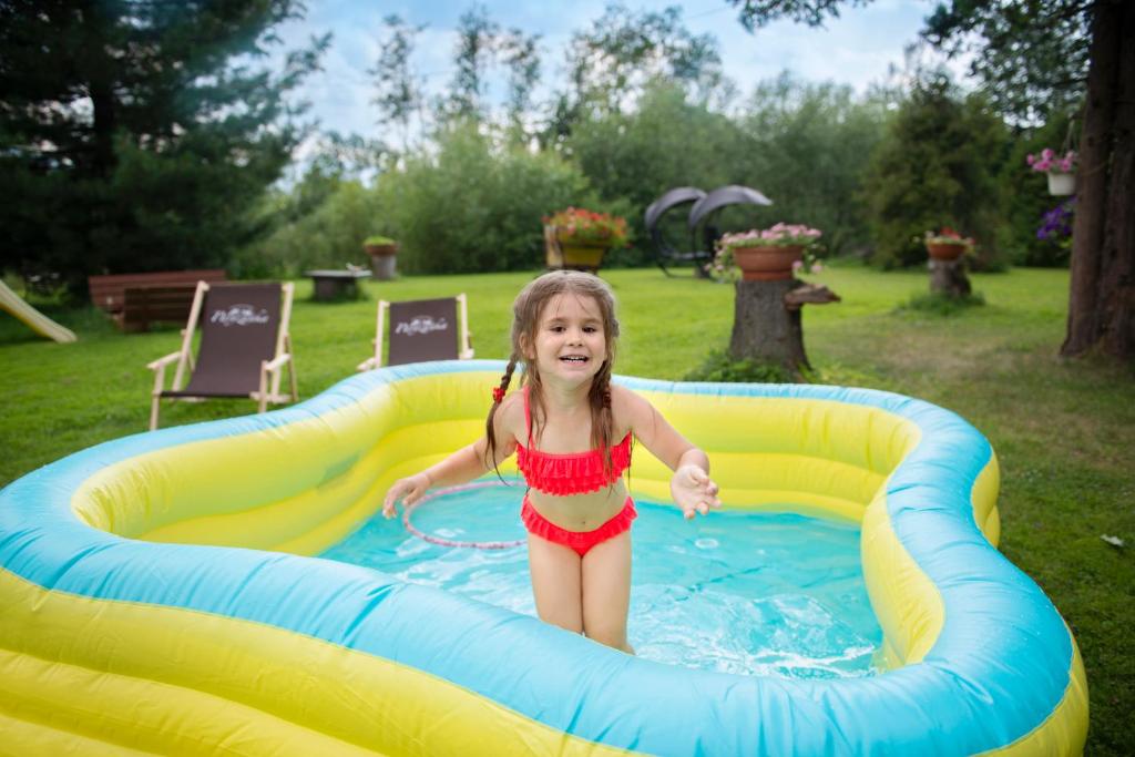 Ein kleines Mädchen spielt in einem aufblasbaren Pool in der Unterkunft DW Paryżanka in Poronin