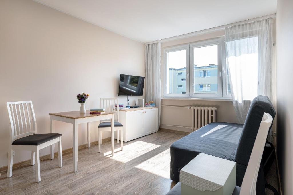 a bedroom with a desk and a bed and a table at INITIUM rooms - Apartament - Tysiąclecia 23B in Gdańsk