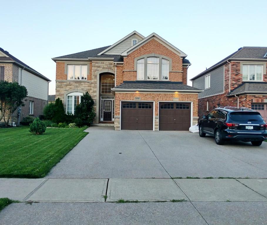 une voiture garée devant une maison en briques dans l'établissement Home Pearl B&B, à Niagara Falls