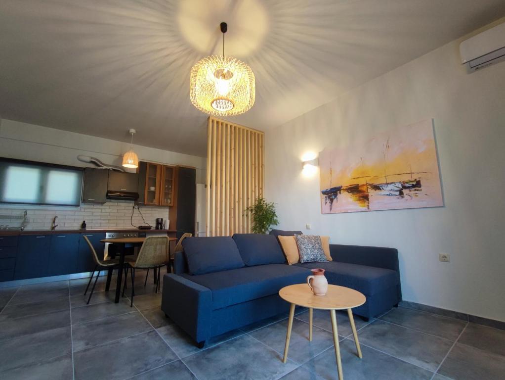 un soggiorno con divano blu e tavolo di Coritos holiday apartments a Kontokali