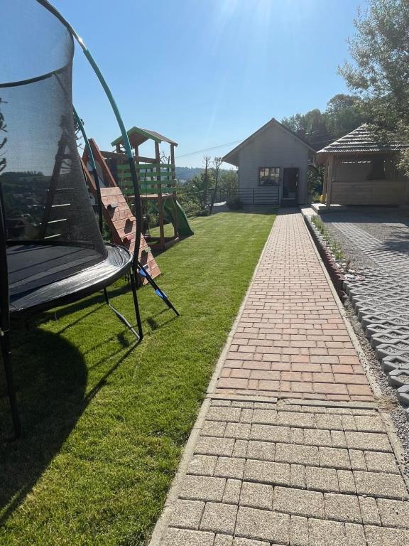 un banc installé sur l'herbe à côté d'une aire de jeux dans l'établissement Domek na Gorczańskiej, à Rabka-Zdrój