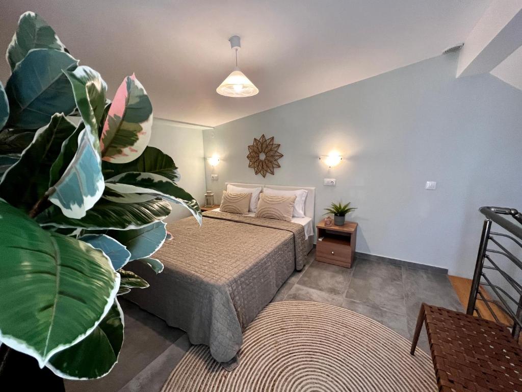 a bedroom with a bed and a large plant at Nikiti Holidays in Nikiti