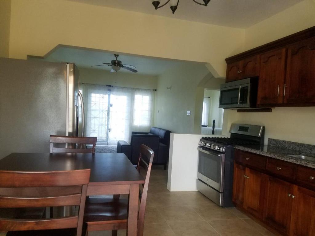 a kitchen and dining room with a table and a stove at Rio View Apartments in Ocho Rios