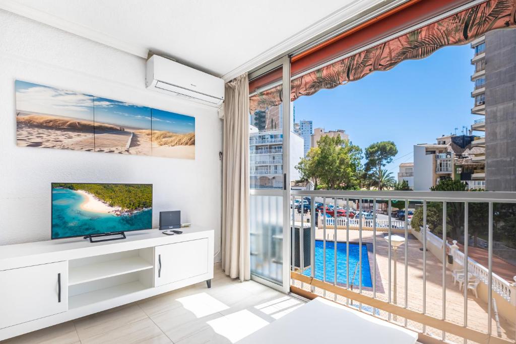 uma sala de estar com televisão e uma grande janela em Carabelas III 1-3 Apartment Levante Beach em Benidorm