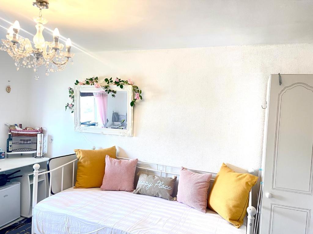 Un dormitorio con una cama con almohadas de colores. en Happy Place with kitchenette- female only, en Sydenham