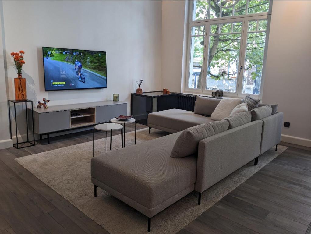 un soggiorno con divano e TV a schermo piatto di luxe en authenticiteit ad Anversa