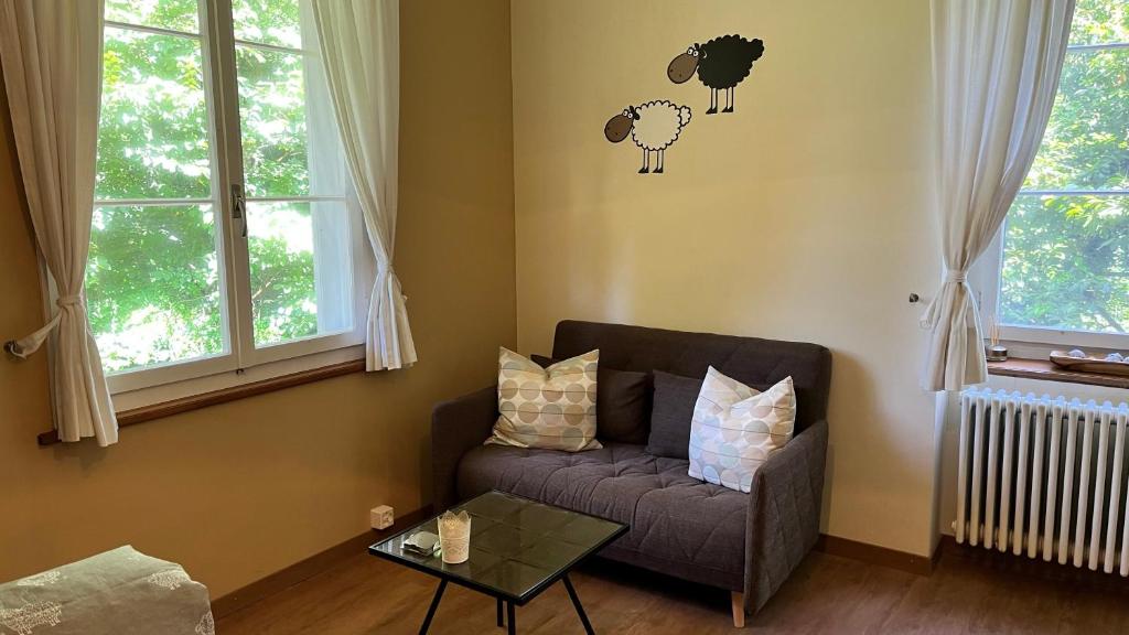 a living room with a couch and two sheep on the wall at Hotel Krone Sihlbrugg in Sihlbrugg Dorf