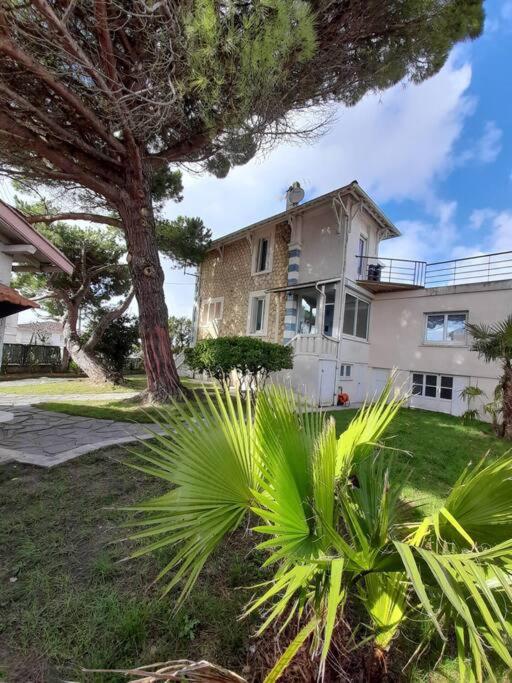 une maison avec un palmier devant dans l'établissement ROYAN - Villa La Cigale - 7 chambres / 16 couchages, à Royan