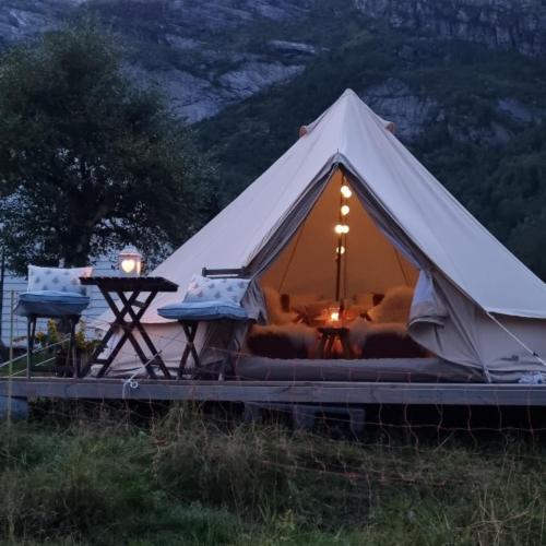 a white tent with a couch and a table at Flatheim Glamping in Viksdalen