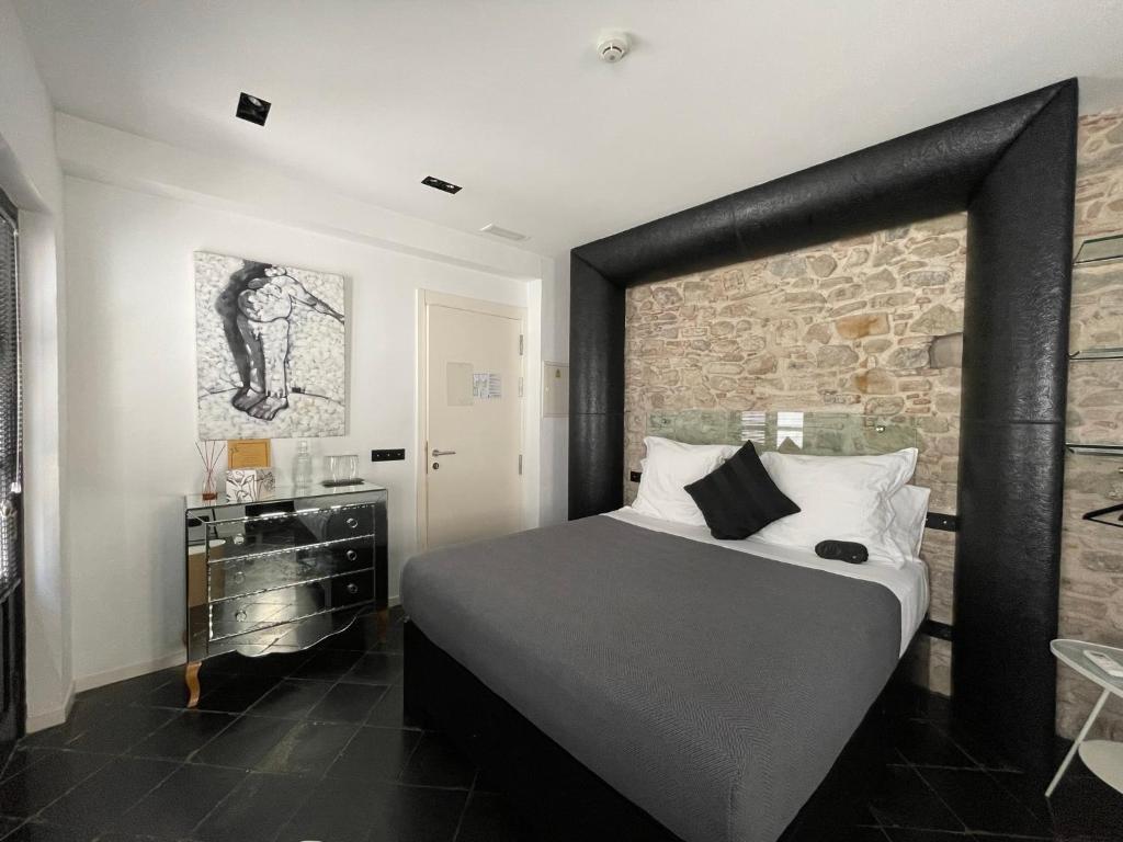 a bedroom with a large bed and a stone wall at Hospedería 16 in Tarifa