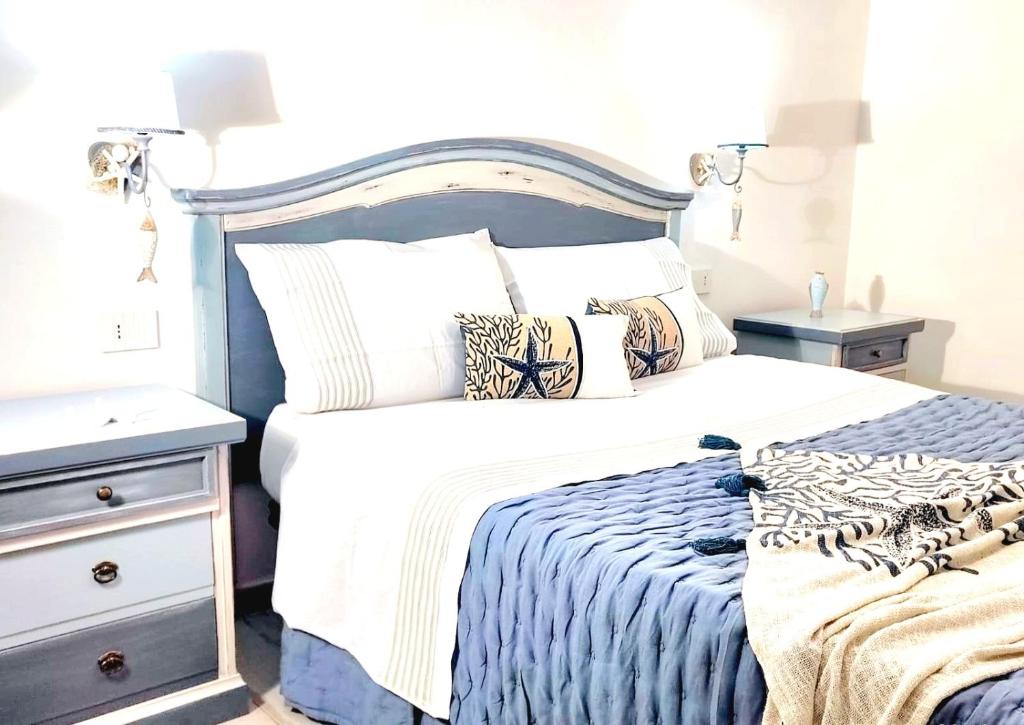 een slaapkamer met een blauw en wit bed en een nachtkastje bij Golden House in Porto Torres