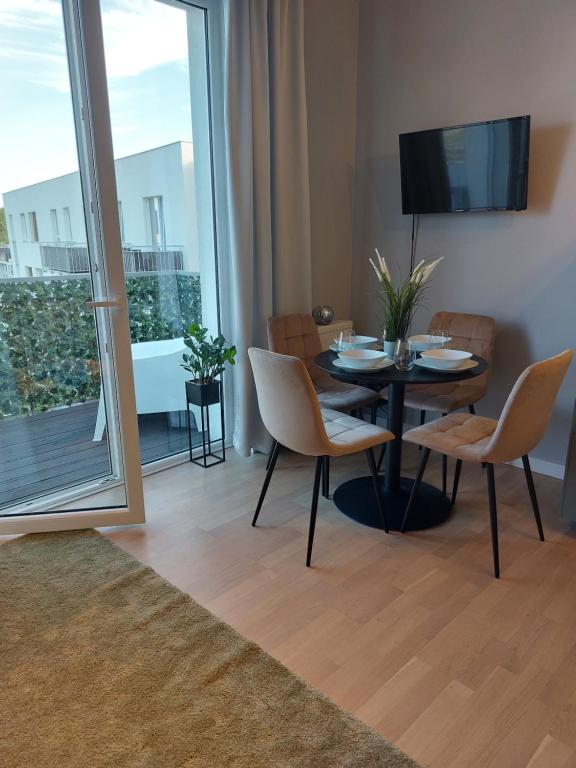 a dining room with a table and chairs and a balcony at Apartament w Gdańsku in Gdańsk