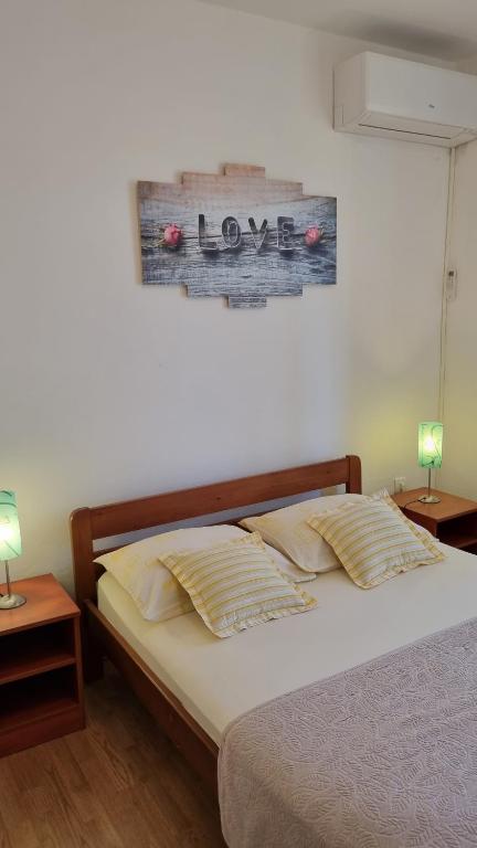 a bedroom with a bed with two night stands and two lamps at Apartman Mila in Belej