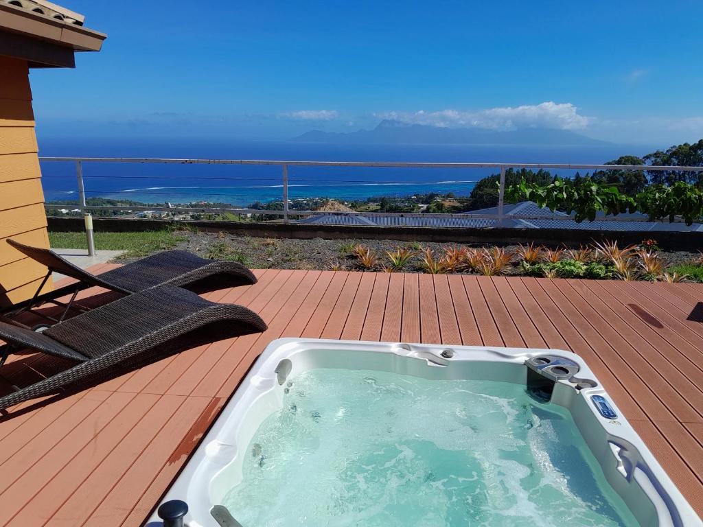 bañera de hidromasaje en una terraza con vistas al océano en Bungalow Miwa, en Punaauia