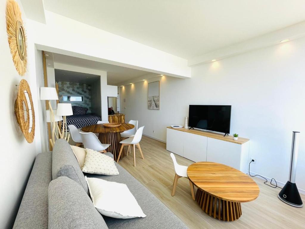 a living room with a couch and a table at Studio FRONT DE MER rénové in Le Barcarès