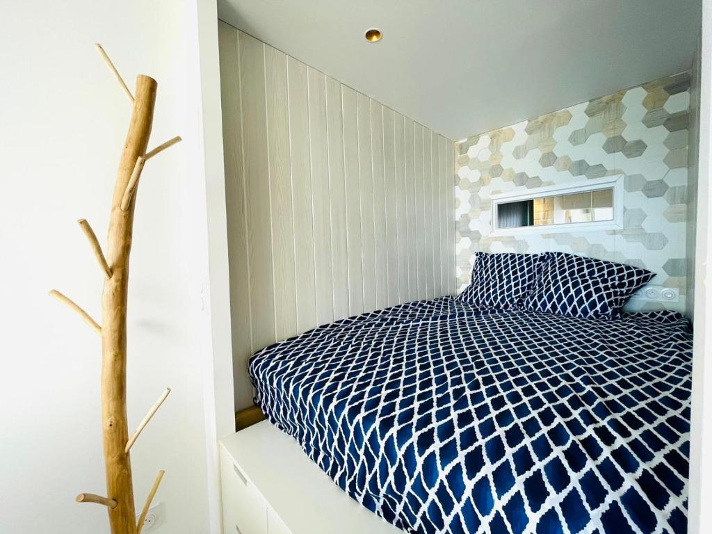 a bedroom with a bed with a blue and white comforter at Studio FRONT DE MER rénové in Le Barcarès