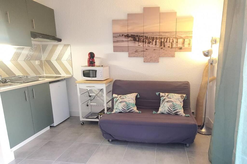 sala de estar con sofá púrpura en la cocina en Studio proche plage tout à pied en Fréjus