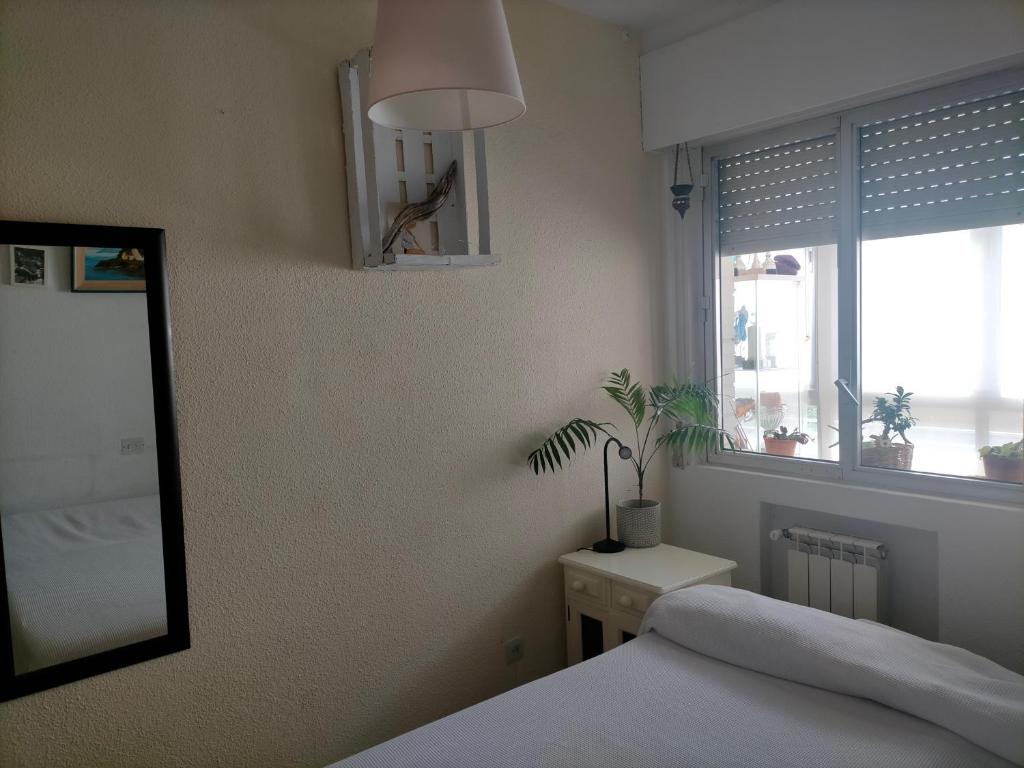 a bedroom with a bed and a mirror and a window at FEMALE ONLY Pinar de Chamartin room in Madrid