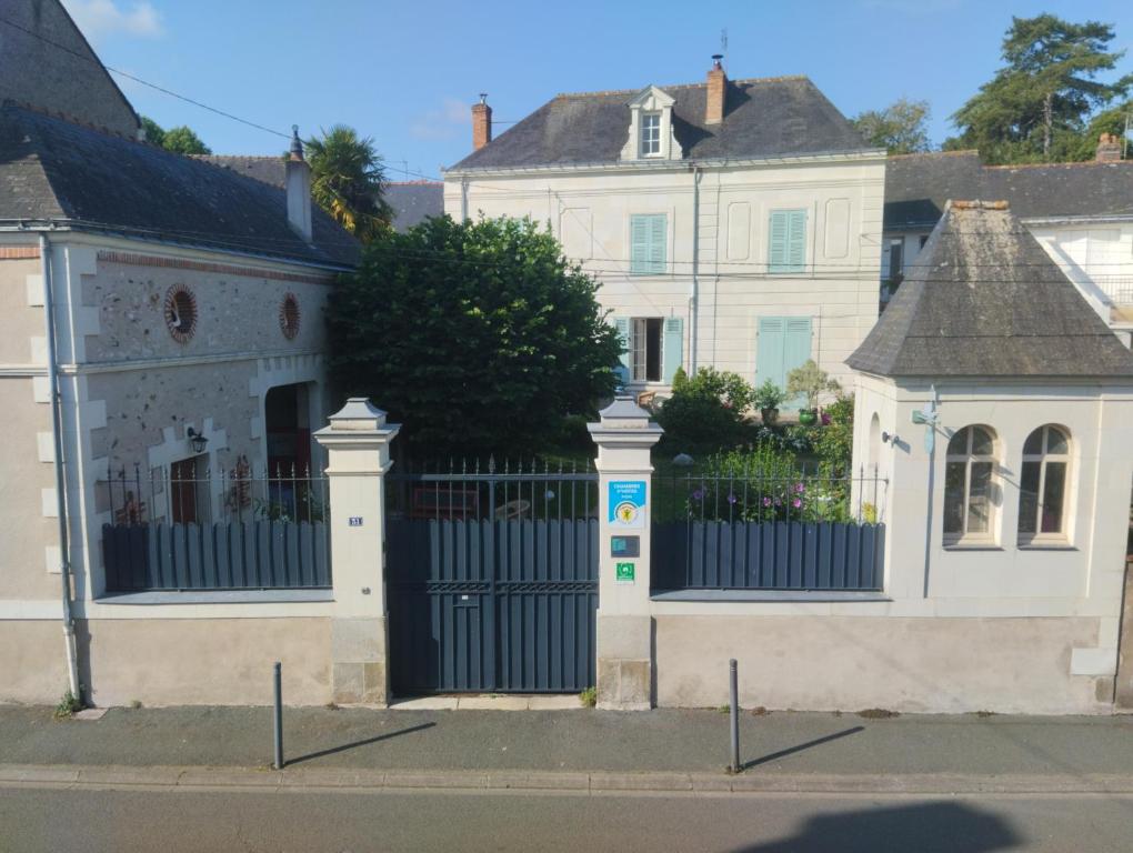 a gate in front of a white house at Les Orkys De Loire in Chalonnes-sur-Loire