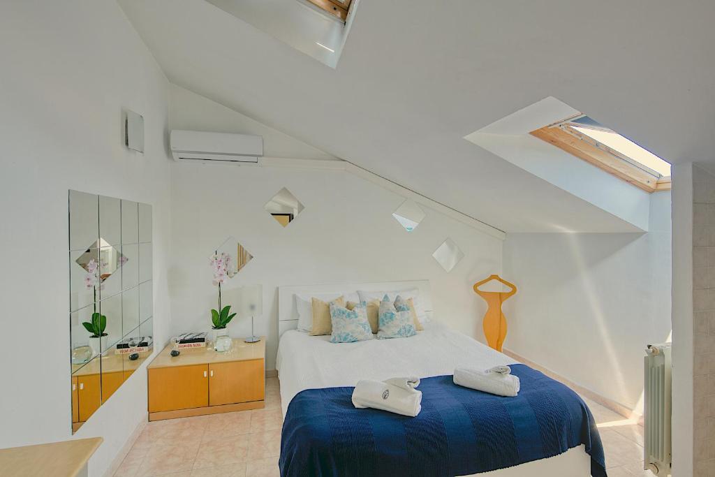 um quarto branco com uma cama e um cobertor azul em Loft Superga on green river Po' Torino em San Mauro Torinese