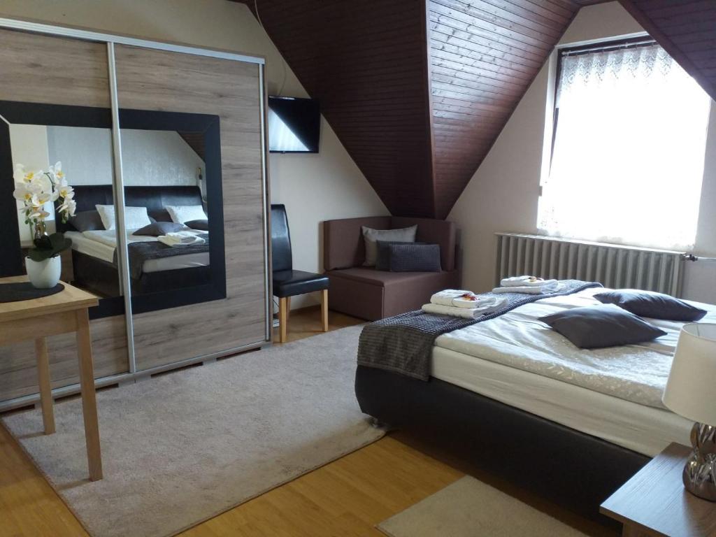een slaapkamer met een groot bed en een bureau bij Aranka Apartman in Gyula