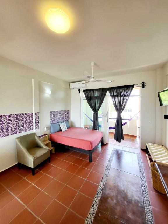 a bedroom with a pink bed and a chair at Casa Puerto Bonito & Private Coworking in Puerto Escondido
