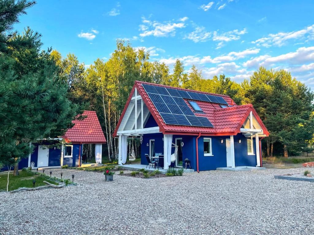 una casa con paneles solares en el techo en Stilo Domki en Sasino
