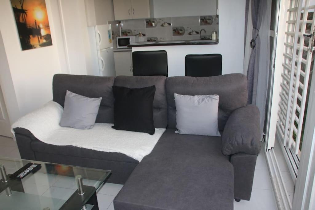 um sofá com almofadas na sala de estar em Appartement à 5 min de la plage em Bouéni
