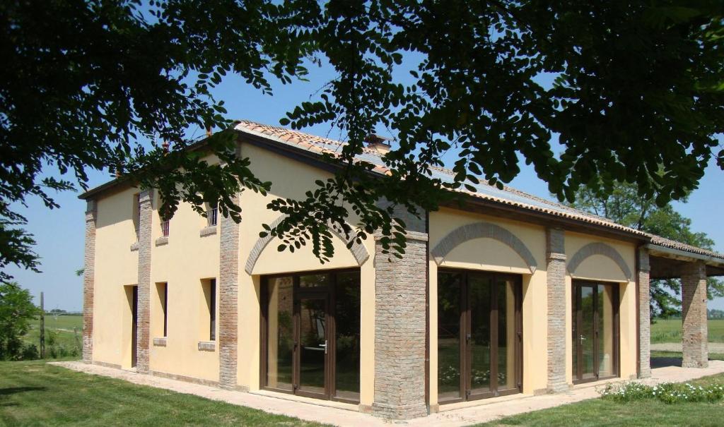 un edificio con ventanas grandes en un lateral en Agriturismo L'Unicorno, en Portomaggiore