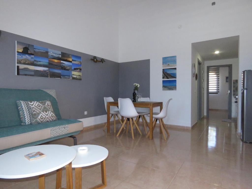 a living room with a couch and a table and chairs at Casa Mona in Corralejo