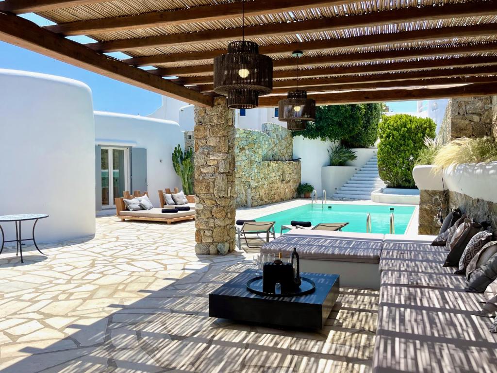 patio ze stołem i basenem w obiekcie Villa Zen - MG Villas Mykonos w mieście Mykonos