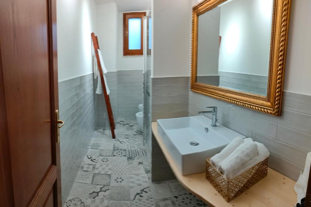 een badkamer met een wastafel en een spiegel bij Residenze del Bosco - Olivo in Tuscania