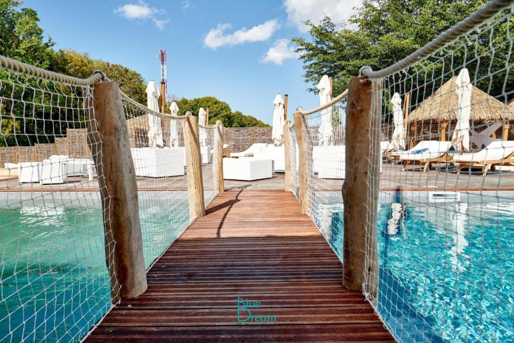 a wooden walkway leading to a swimming pool at TOUMALACAÏ Appart 245 in Folle Anse