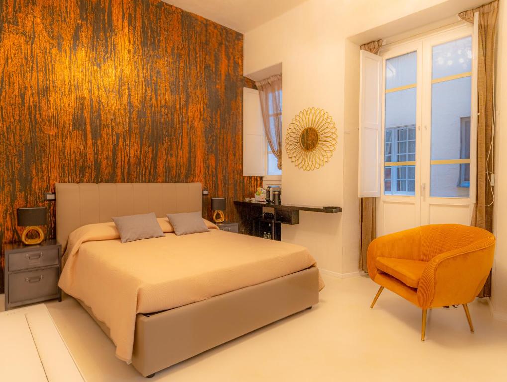 - une chambre avec un lit, une chaise et une fenêtre dans l'établissement Flower Rooms Cagliari, à Cagliari