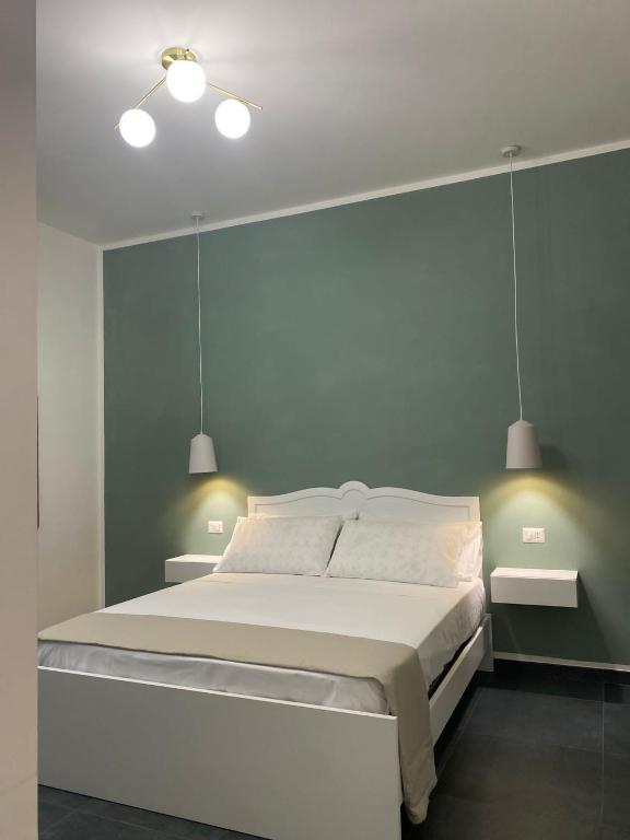 a bedroom with a large bed with two lights on it at DomusEli in Santa Maria di Castellabate
