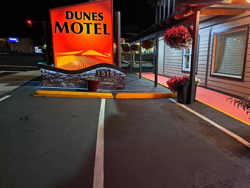 a sign for a dunes motel on a street at Dunes Motel - Bend in Bend