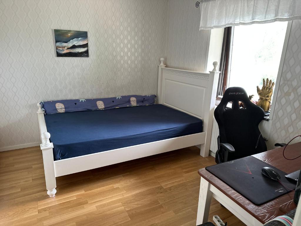 - une chambre avec un lit doté de draps bleus et une fenêtre dans l'établissement Terminate service, à Täby