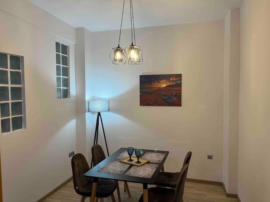 uma sala de jantar com uma mesa com cadeiras e um candeeiro em Nick's Place em Tessalônica
